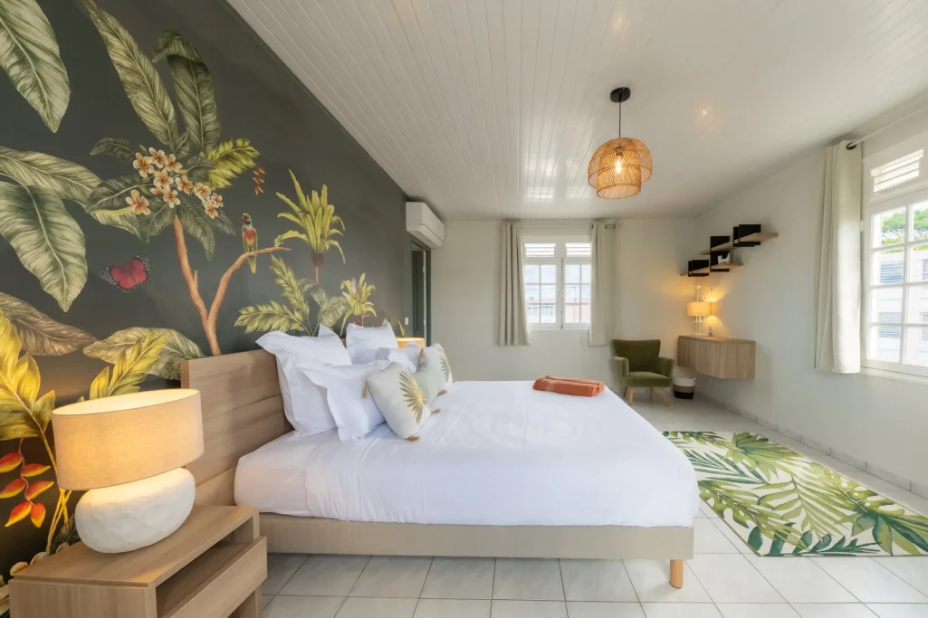 Chambre lumineuse avec mur végétal, lit double et décor moderne.