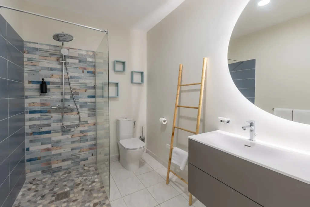 Salle de bains moderne avec douche, lavabo et décoration minimaliste.
