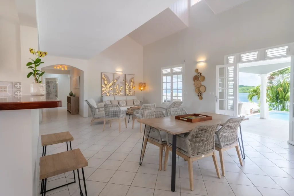 Salle à manger lumineuse avec mobilier moderne et accès à une terrasse extérieure.